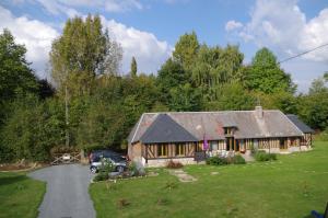 ein Haus mit einem davor geparkten Auto in der Unterkunft Ndila Cottage piscine privée in Fatouville-Grestain