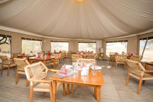 a dining room with tables and chairs in a tent at Malaika Ndutu Luxury Camp in Sinoni +24 photos
