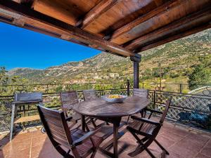 uma mesa de madeira e cadeiras numa varanda com vista em ViP Suite 4 Seasons em Arachova