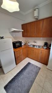 a kitchen with a white refrigerator and a sink at Relax - Patras Apartment in Patra