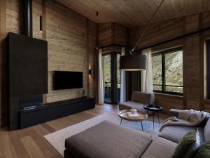 a living room with a couch and a tv at Andermatt Alpine Apartments in Andermatt