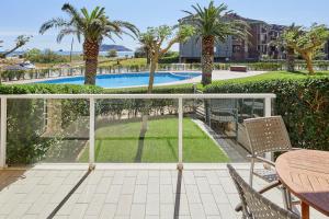 a balcony with a table and chairs and a pool at Apartamentos Rodamar in L'Estartit