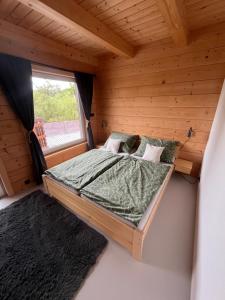 a bed in a wooden room with a window at Roubenka Olešná na Moravě in Olešná +35 photos