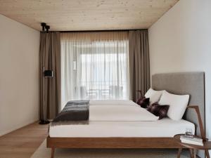 a bedroom with a large bed and a window at Andermatt Alpine Apartments in Andermatt