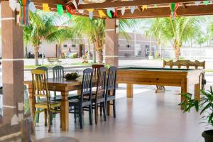 a dining area with a table and chairs and a pool table at Hotel Terceiro Milênio II in Brumado
