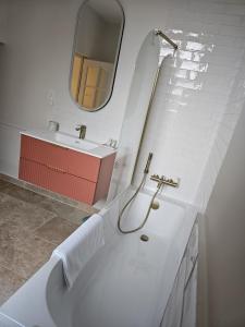 a white bathroom with a sink and a mirror at Château de la Follie Le Berne in Pierrefonds