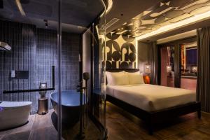 ein Schlafzimmer mit Bett, Badewanne und Waschbecken in der Unterkunft Pynt Hotel 8 in Ho-Chi-Minh-Stadt