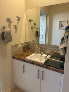 a bathroom with a sink and a mirror at The Nest at Forest Lake - Stylish Guest Suite in Kangaroo Flat +29 photos