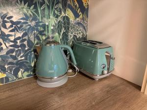 two green appliances are sitting on a wooden floor at The Nest at Forest Lake - Stylish Guest Suite in Kangaroo Flat