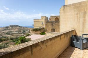 a bench sitting on a wall looking out at the ocean at Ta Marija in Żebbuġ