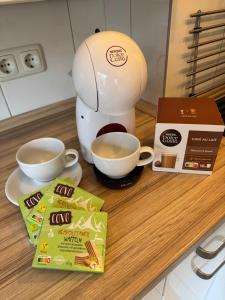 a coffee maker on a counter with two cups of coffee at Kleines Studio Albatros in Bremerhaven +16 photos