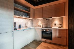 a kitchen with white cabinets and wooden counters at Kikut Alpin Lodge 2102 in Hol +8 photos