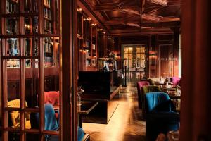 a living room with chairs and a television and a library at Hotel Halm Konstanz in Konstanz