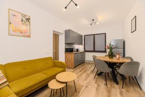 a living room with a yellow couch and a table at Old Town Urban Nest in Braşov +16 photos