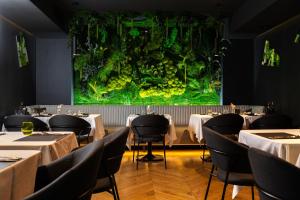 a restaurant with tables and a large aquarium at B THE HOTEL in Sfântu-Gheorghe