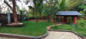 a garden with a small house and a playground at Gangadharam Tiny House 2BHK AC in Tellicherry
