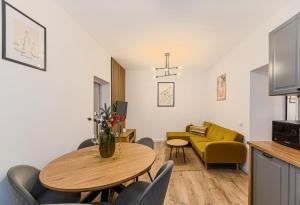 a living room with a table and a yellow couch at Old Town Urban Nest in Braşov