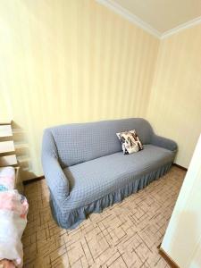 a blue couch in the corner of a room at Аэропорт Астана 5 минут 1 in Astana