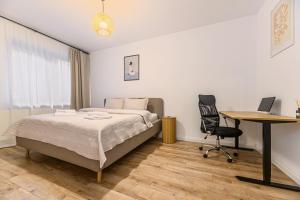 a bedroom with a bed and a desk and a computer at Old Town Urban Nest in Braşov