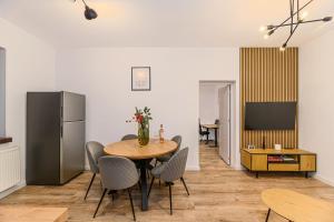 a dining room with a table and chairs and a refrigerator at Old Town Urban Nest in Braşov