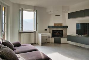 a living room with a couch and a fireplace at Terrazza in centro Valsassina in Introbio