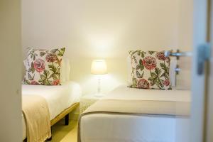 a bedroom with two beds with pillows and a lamp at Sintra Bliss A Part in Sintra