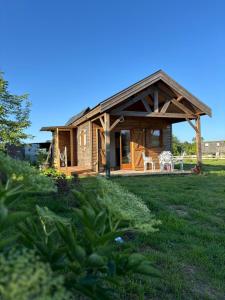 a log cabin with a porch and a lawn at Un Chalet au Verger-Dog friendly-Jacuzzi & Massages in Conteville
