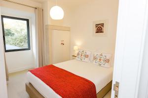 a white bedroom with a bed with a red blanket at Sintra Bliss A Part in Sintra