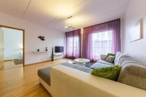 a living room with a couch and a large window at Hilltop Apartments - City Centre Foorum in Tallinn