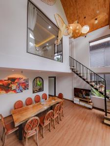 a dining room with a table and chairs and a staircase at Thung May Resort - Venuestay in Ba Vì