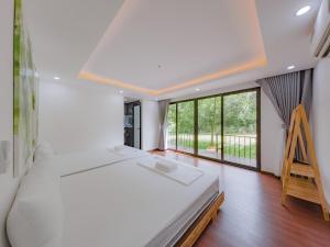 a bedroom with a large bed and a large window at Thung May Resort - Venuestay in Ba Vì +51 photos