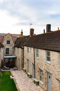 a row of brick buildings with benches in the courtyard at Number One Bruton in Bruton