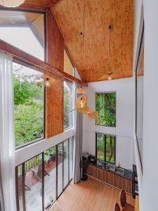 an open living room with large windows and wooden ceilings at Thung May Resort - Venuestay in Ba Vì