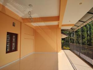 an empty house with orange walls and a balcony at Bridgettine Paradise in Sultan Bathery
