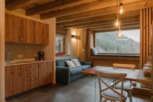 a kitchen and living room with a table and a couch at Chalet Noèr in Ledro