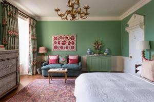 a bedroom with green walls and a bed and a couch at Number One Bruton in Bruton +31 photos