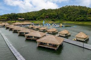 a row of huts in the water with a water park at Ruknam Resort in Ban Hin Hak