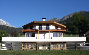 a house in a field with mountains in the background at Haus Nikola in Telfes im Stubai