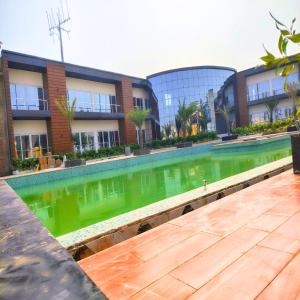 a pool of green water in front of a building at Riyank Farms in Patna