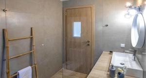 un bagno con doccia, lavandino e WC di Olive Waves apartments a Néa Péramos Altre 63 foto