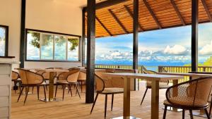 a restaurant with tables and chairs and a view of the ocean at Six Pillars Resort in Bastimentos