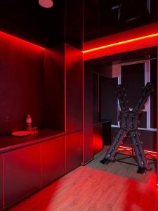 a red room with a bar with a chair in it at RED Тематичні Апартаменти in Zhytomyr