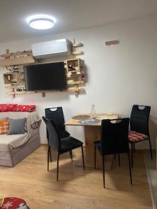 a living room with a table and chairs and a couch at ChiaraKop in Kopaonik