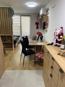 a kitchen with a table and chairs and a living room at ChiaraKop in Kopaonik +4 photos