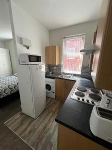 a small kitchen with a refrigerator and a stove at Comfy private studio Moseley in Birmingham