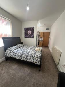 a bedroom with a bed and a kitchen in it at Comfy private studio Moseley in Birmingham