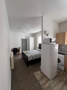 a small room with a bed and a refrigerator at Comfy private studio Moseley in Birmingham +8 photos