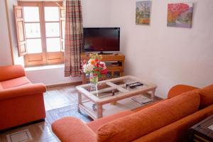 a living room with a couch and a table with flowers at Vivienda Rural Prado in Berja