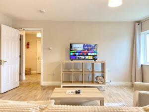 a living room with a couch and a tv on a wall at Anchors Rest, Cobh in Cobh