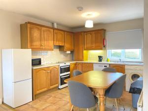 a kitchen with a table and a white refrigerator at Anchors Rest, Cobh in Cobh